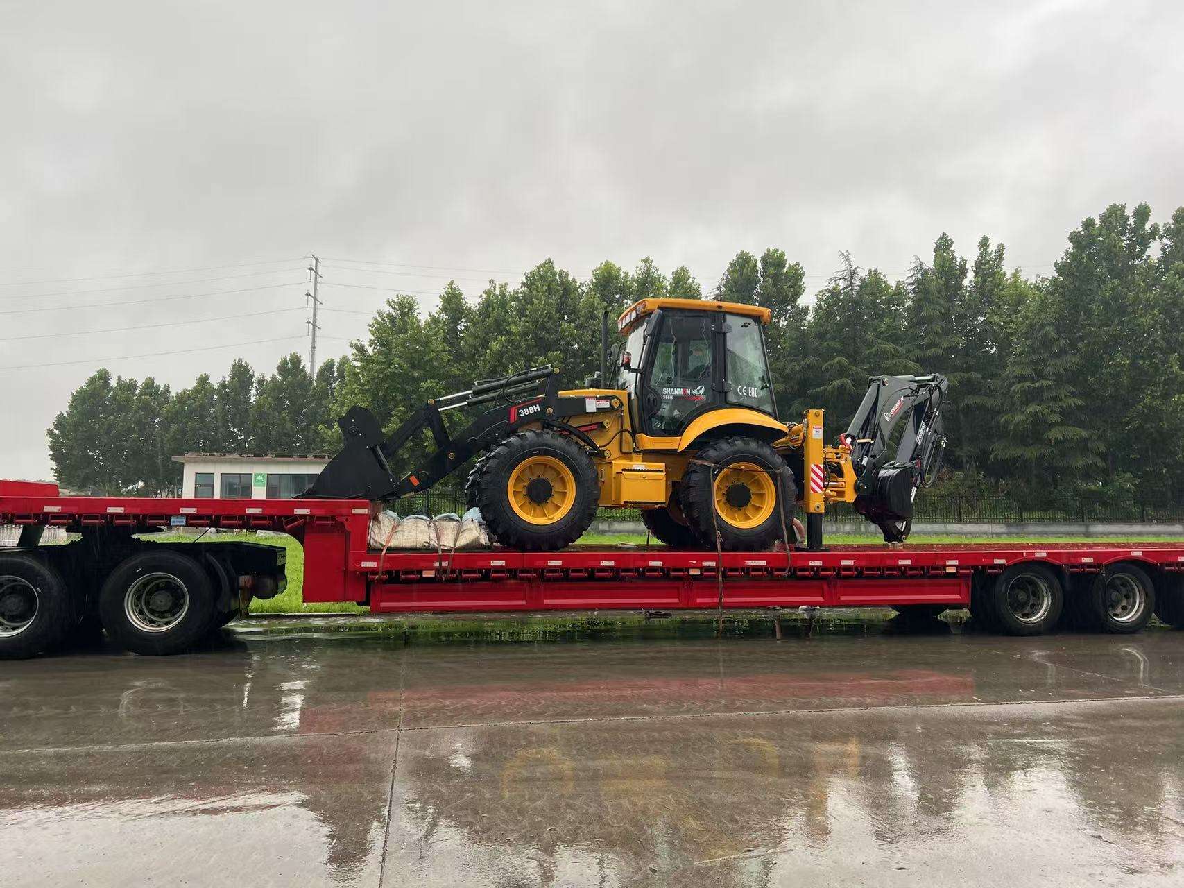 Backhoe loader Shanmon 388H telah dimuat ke truk bak datar dan siap dikirim